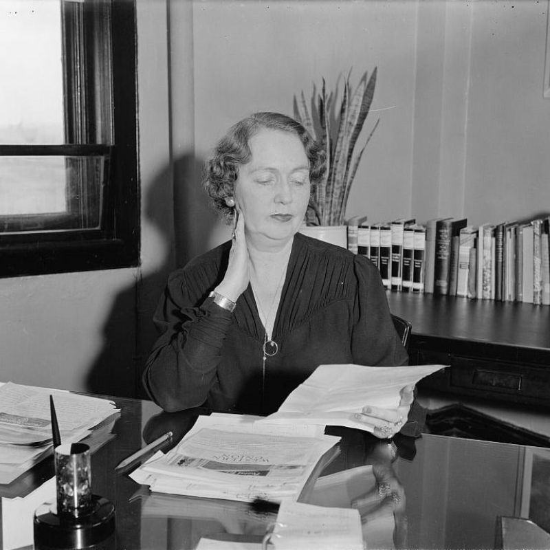 A black and white photo of Molly Dewson sitting at a desk